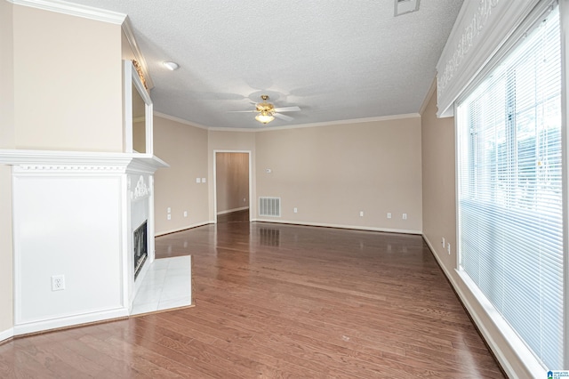 unfurnished living room featuring crown molding, a textured ceiling, ceiling fan, and dark hardwood / wood-style floors