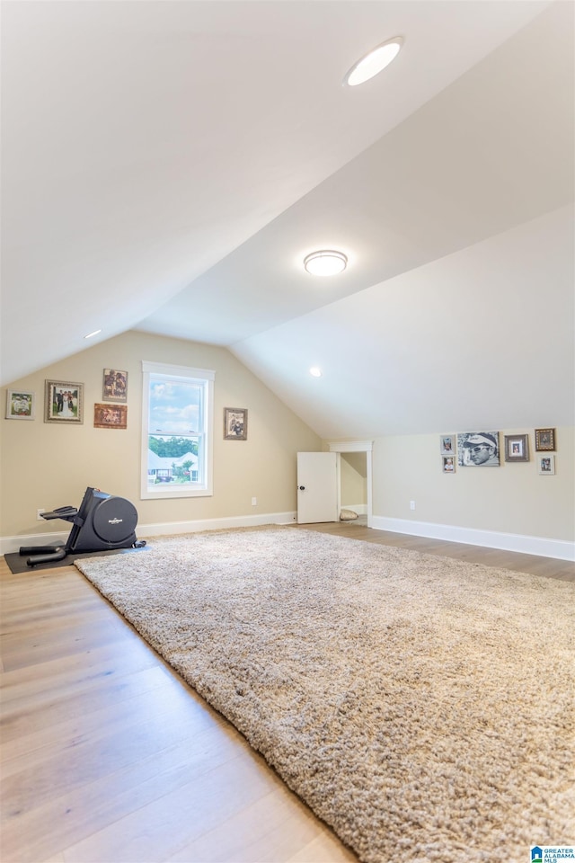 additional living space featuring baseboards, vaulted ceiling, and wood finished floors