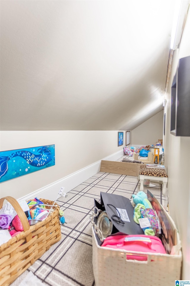 recreation room with vaulted ceiling and baseboards