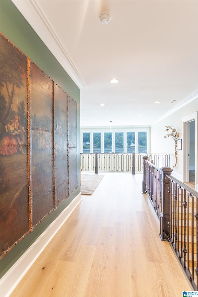 corridor featuring light wood-style flooring and crown molding