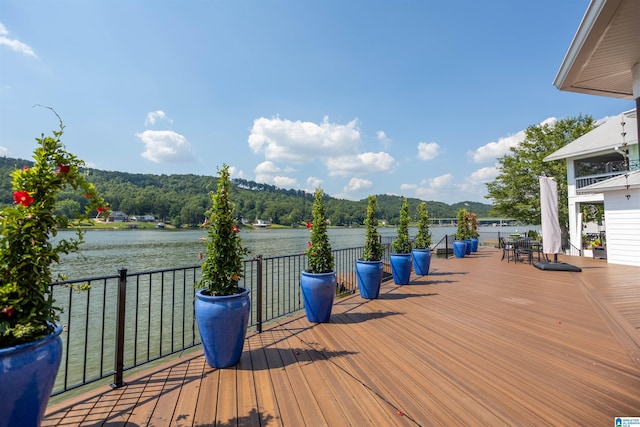 wooden terrace with a water view and a forest view