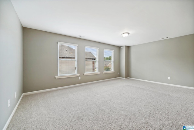 carpeted empty room featuring visible vents and baseboards