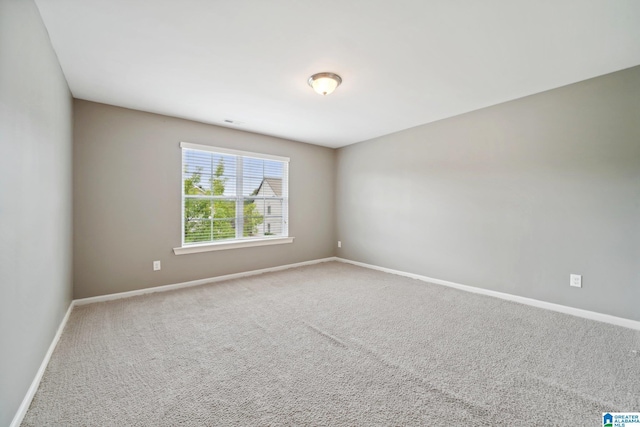 spare room with baseboards and carpet floors