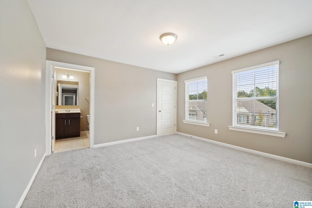 unfurnished bedroom with visible vents, light colored carpet, and baseboards