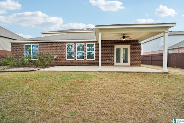 rear view of house with a lawn, fence, french doors, brick siding, and a patio area