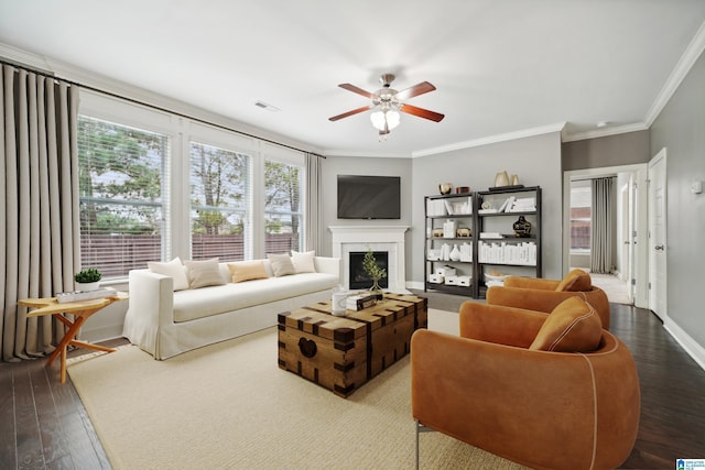 living area with visible vents, baseboards, dark wood finished floors, a fireplace, and crown molding