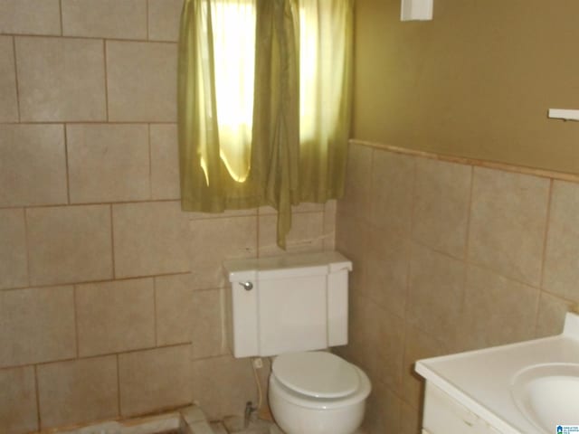 bathroom featuring tile walls, toilet, and vanity