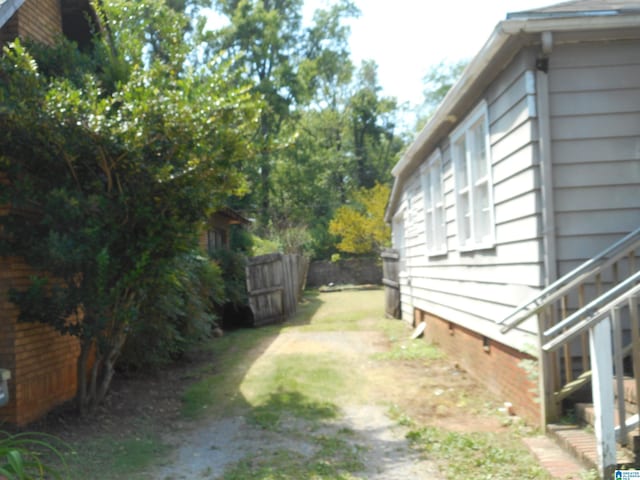 view of yard featuring driveway and fence