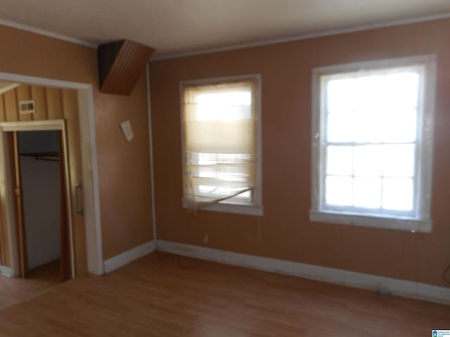 interior space featuring crown molding, visible vents, baseboards, and wood finished floors