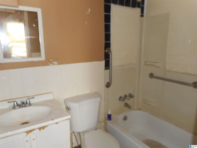 full bathroom featuring wainscoting, toilet, bathtub / shower combination, vanity, and tile walls