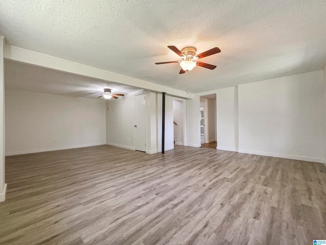 empty room with a textured ceiling, ceiling fan, and hardwood / wood-style flooring