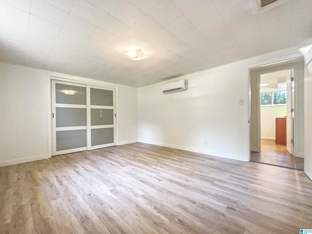 spare room featuring light hardwood / wood-style flooring and an AC wall unit