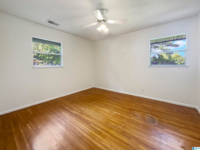 unfurnished room featuring hardwood / wood-style floors, ceiling fan, and a textured ceiling