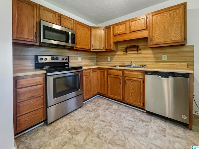 kitchen featuring light tile patterned floors, stainless steel appliances, sink, and decorative backsplash