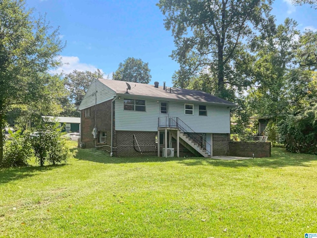 rear view of property with a yard and central AC