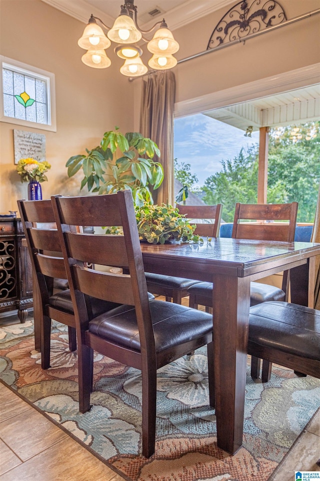 dining space with a healthy amount of sunlight, an inviting chandelier, and ornamental molding