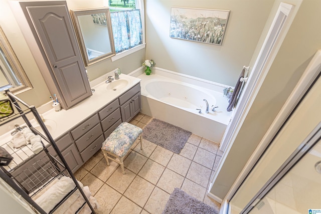 full bathroom featuring tile patterned flooring, vanity, and a tub with jets