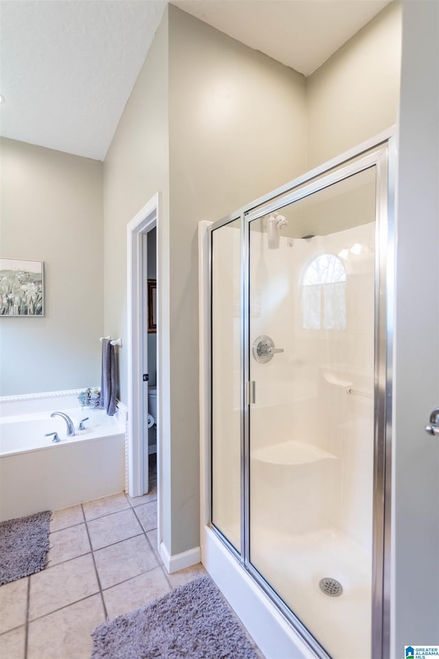 full bath featuring a garden tub, tile patterned flooring, toilet, baseboards, and a shower stall