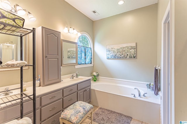 bathroom featuring vanity, tile patterned flooring, a garden tub, and visible vents