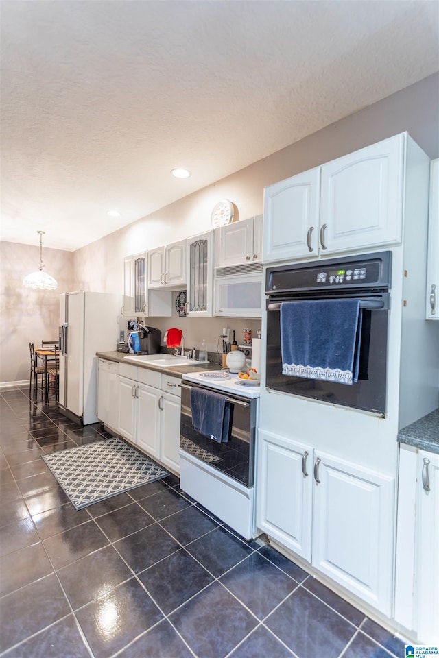 kitchen with glass insert cabinets, white appliances, white cabinetry, and hanging light fixtures