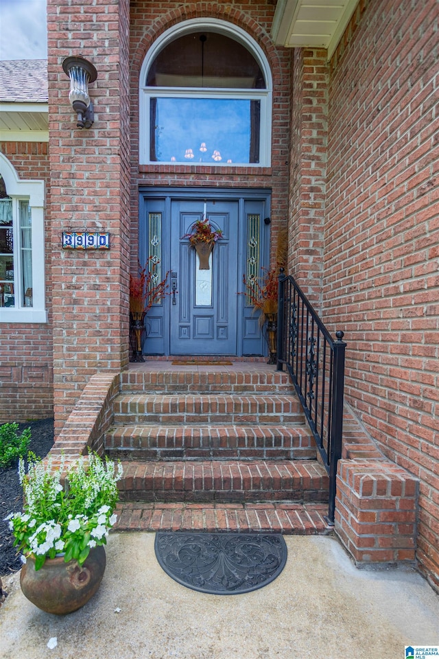 view of exterior entry featuring brick siding