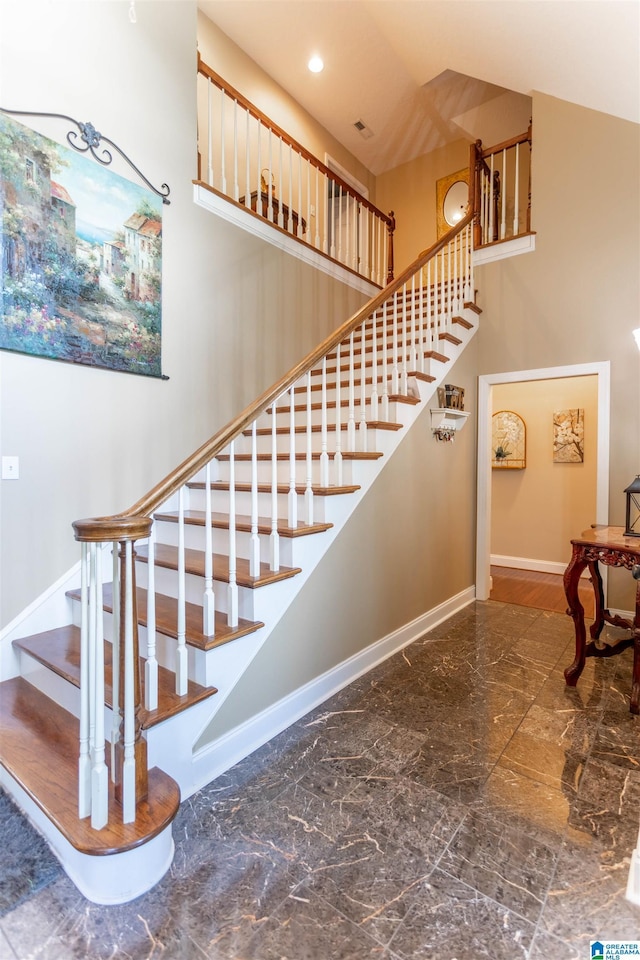 staircase featuring marble finish floor, a high ceiling, recessed lighting, and baseboards