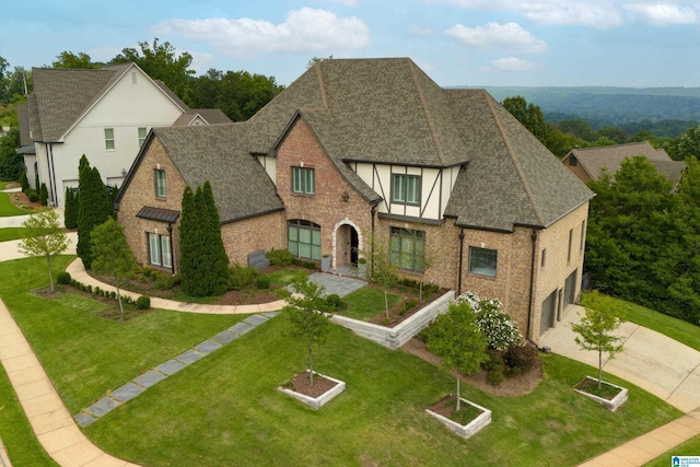 view of front of home featuring concrete driveway, a front yard, roof with shingles, and stucco siding