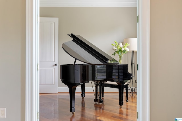 sitting room featuring crown molding, wood finished floors, and baseboards