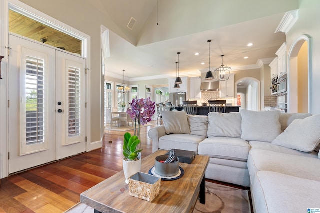 living area featuring ornamental molding, recessed lighting, french doors, arched walkways, and dark wood-style flooring