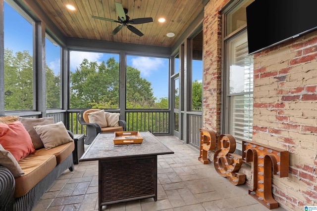 sunroom / solarium featuring a wealth of natural light, wooden ceiling, and a ceiling fan