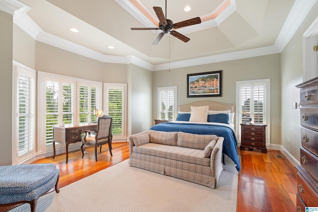 bedroom with crown molding, baseboards, recessed lighting, light wood-style floors, and a raised ceiling