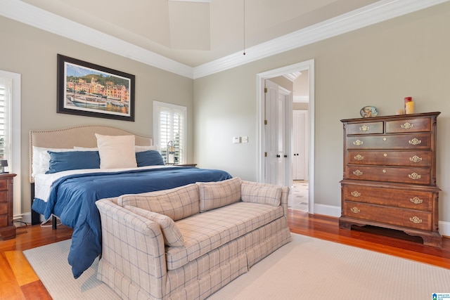 bedroom featuring ornamental molding, baseboards, and wood finished floors