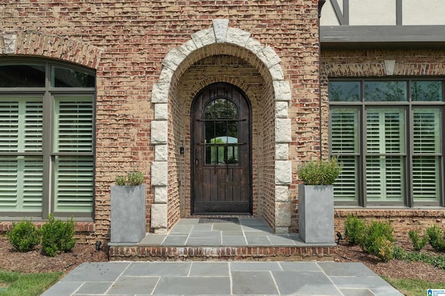 doorway to property with brick siding