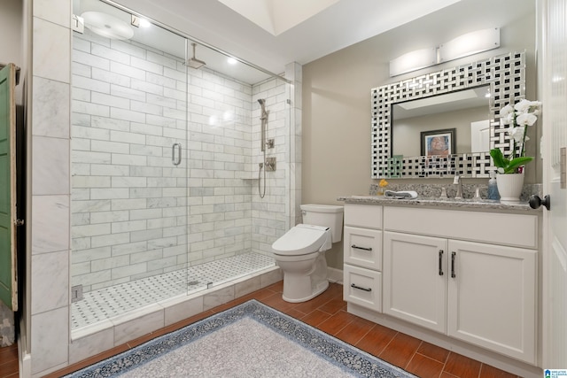 full bathroom featuring vanity, toilet, a stall shower, and wood tiled floor