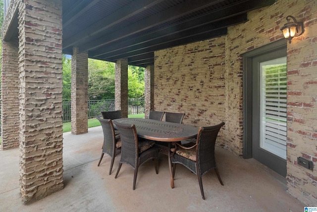 view of patio featuring outdoor dining area and fence