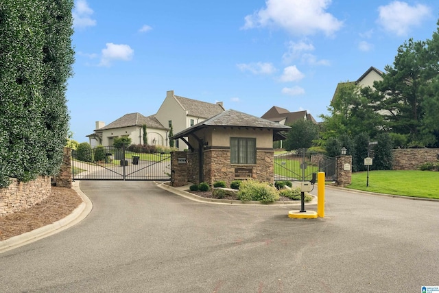 view of street featuring a gated entry, curbs, and a gate