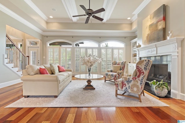 living room with wood finished floors, baseboards, a high end fireplace, ornamental molding, and stairs