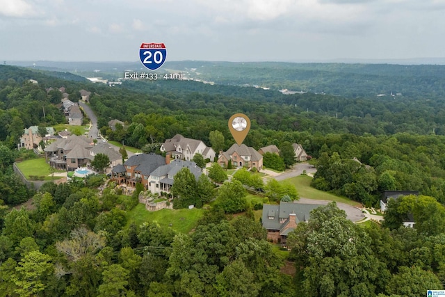 drone / aerial view featuring a residential view and a wooded view