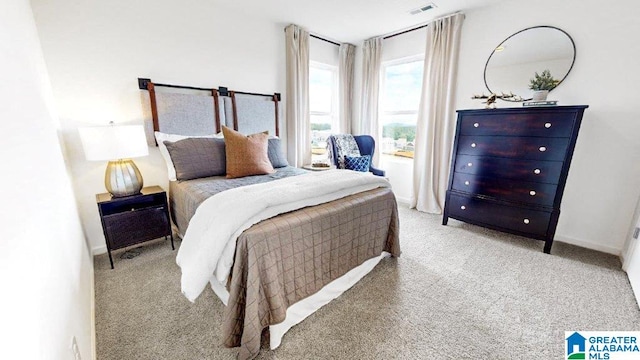 bedroom with carpet floors, visible vents, and baseboards