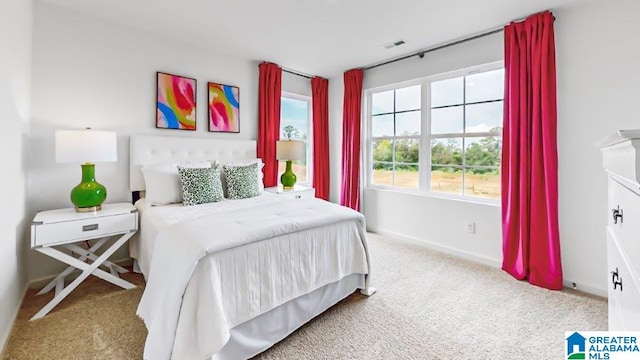 carpeted bedroom with visible vents and baseboards