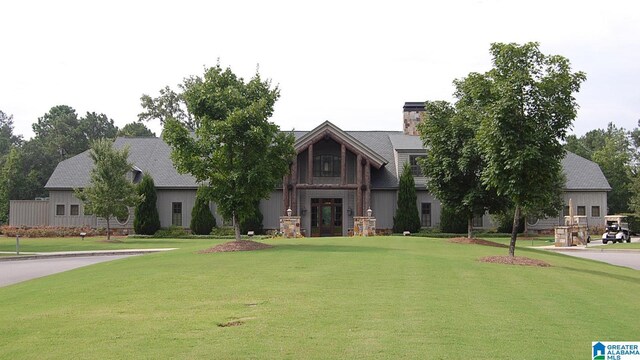 view of front of property with a front yard, french doors, and a chimney