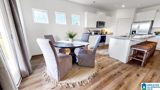 dining space with light wood-type flooring, baseboards, and recessed lighting