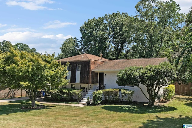 view of front of house with crawl space, brick siding, fence, and a front lawn