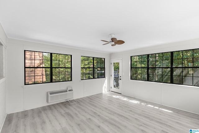 empty room with plenty of natural light, ceiling fan, and wood-type flooring