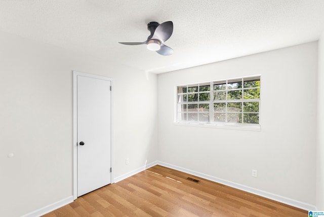 unfurnished room featuring a textured ceiling, light hardwood / wood-style flooring, and ceiling fan