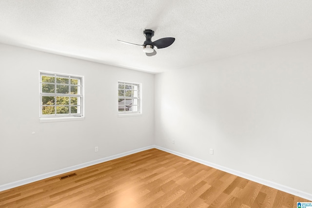 empty room with ceiling fan, a textured ceiling, and light hardwood / wood-style flooring