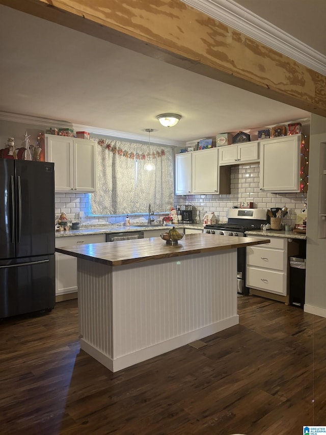 kitchen featuring a sink, hanging light fixtures, stainless steel gas range, freestanding refrigerator, and a center island