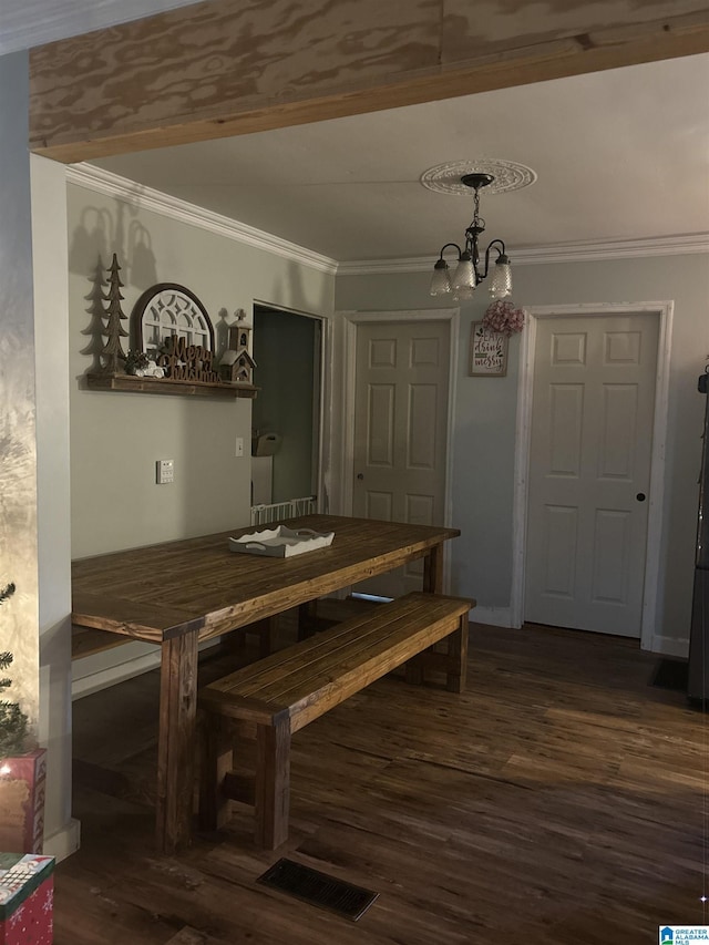 unfurnished dining area with dark hardwood / wood-style floors, crown molding, and a chandelier