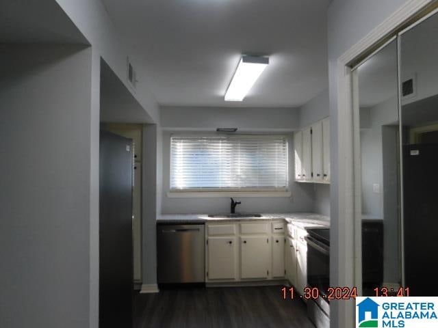 kitchen with white cabinets, light countertops, dishwasher, and a sink