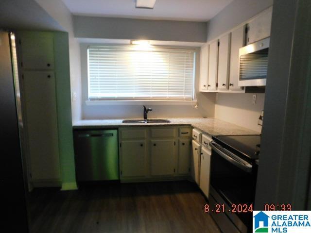 kitchen with stainless steel appliances, dark wood-type flooring, a sink, and light stone countertops